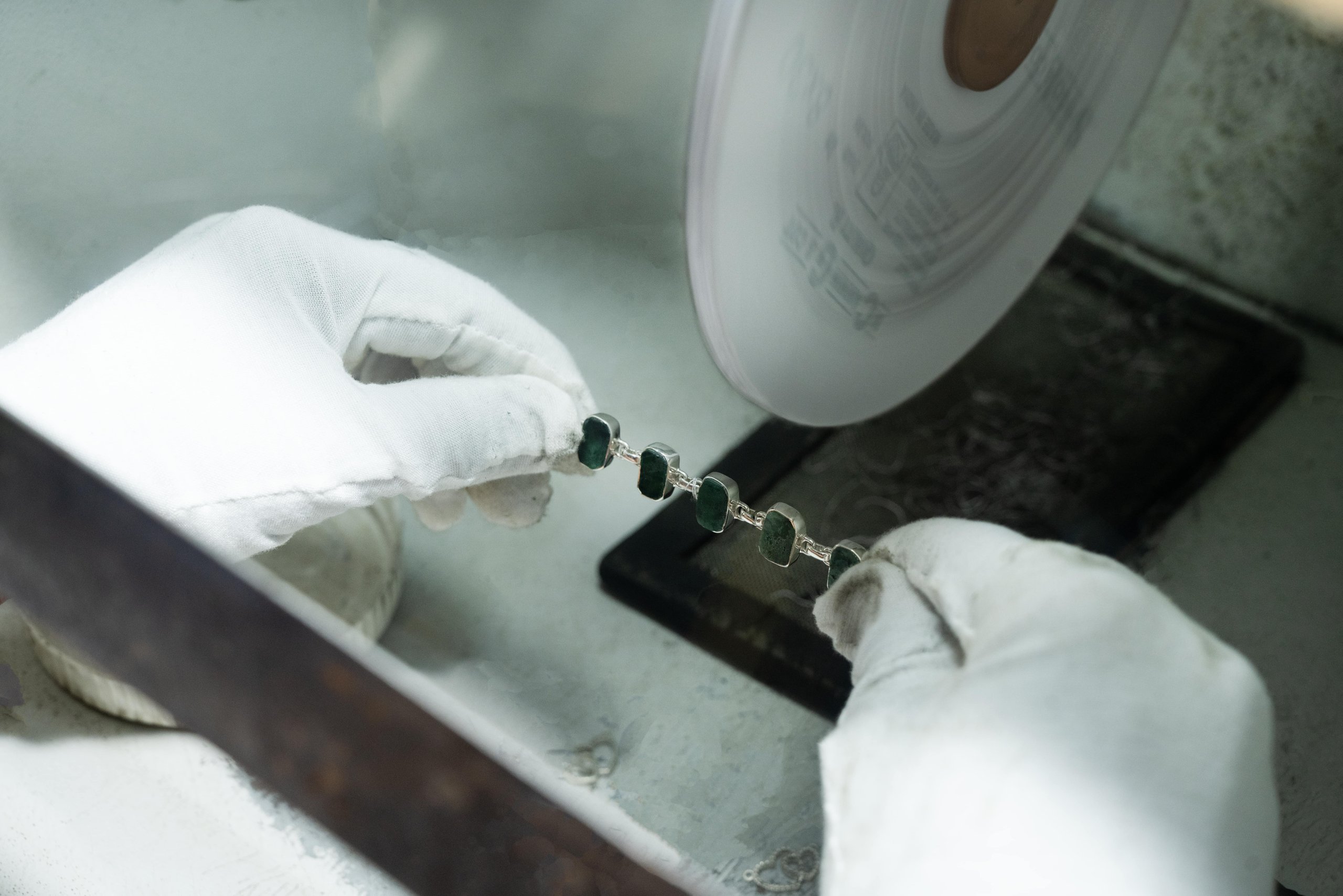 Hand-polishing a gem-set silver bracelet on the buffing wheel