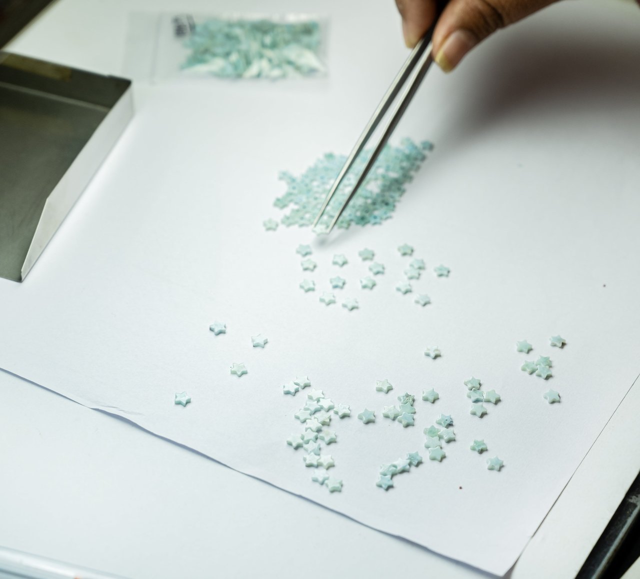 Hand-sorting natural gemstones with tweezers