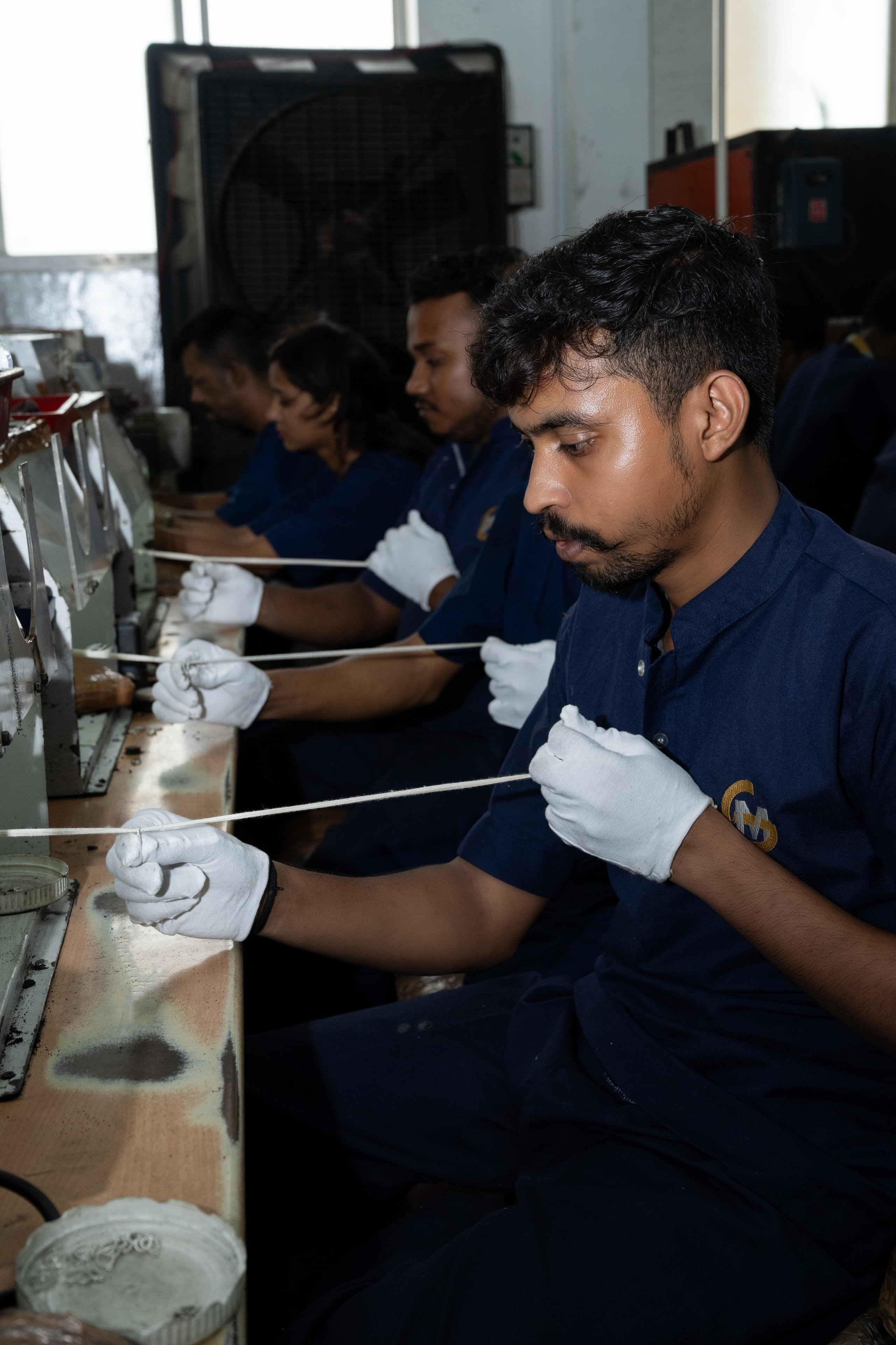 Artisans hand-filing and refining silver pieces