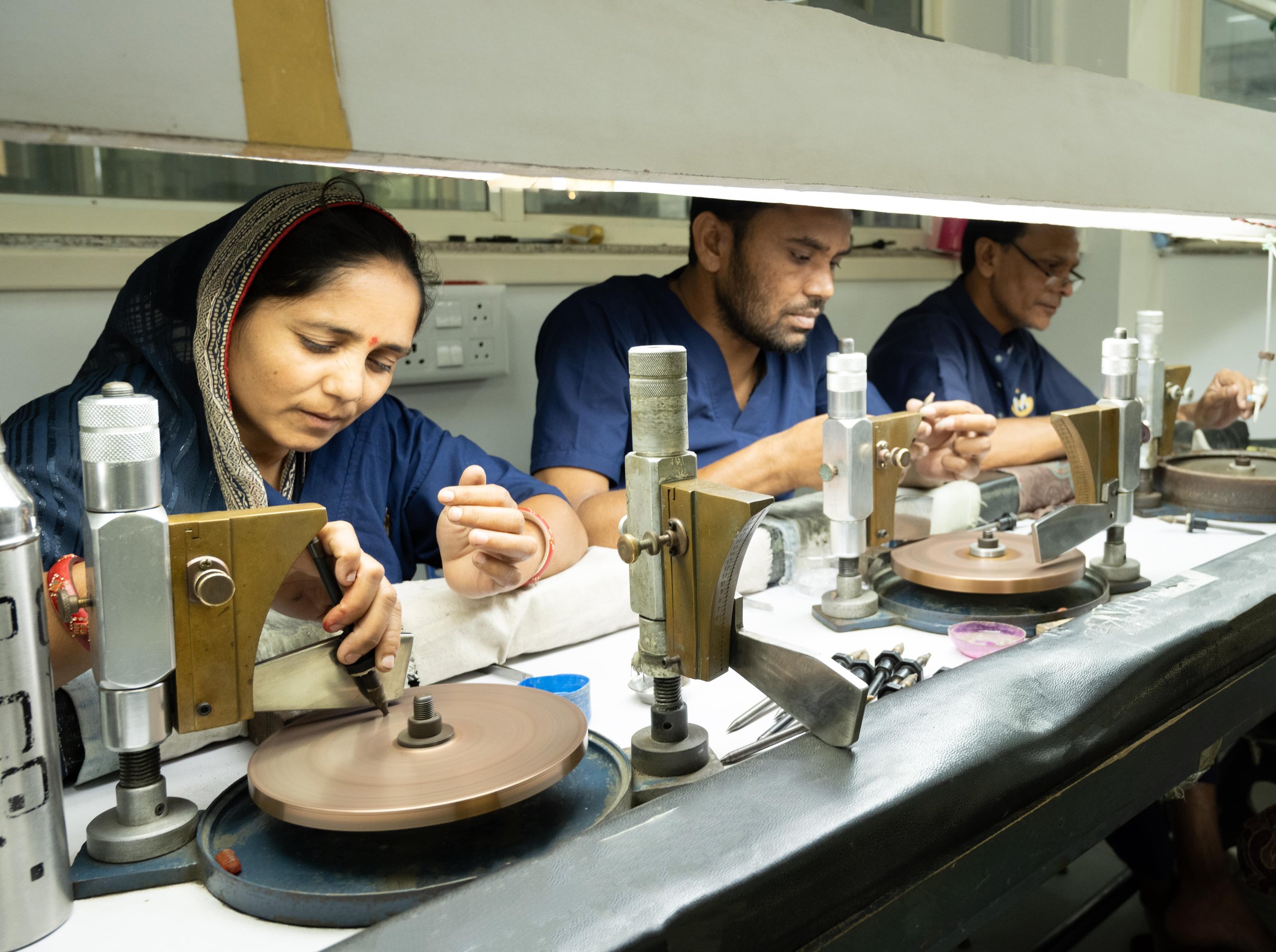 Lapidary artisans cutting natural gemstones at the Blazels workshop in Jaipur