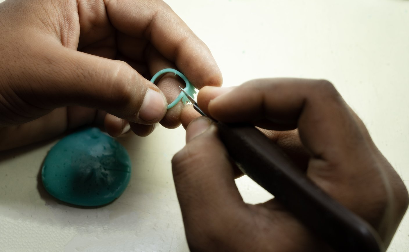 Artisan hand-cleaning and refining a wax ring pattern